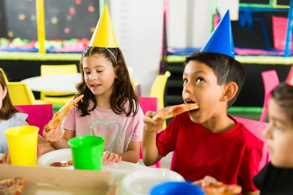 一群快乐的孩子一边吃着美味的披萨和蛋糕 一边在操场上和朋友们一起庆祝生日 — 图库照片