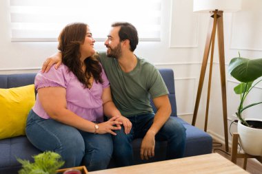 Romantik çift evde romantik bir randevu yaşarken ve kanepede birlikte otururken öpüşmek üzereler.
