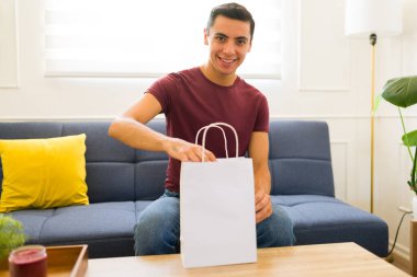 Mutlu Meksikalı genç adam elinde fotokopi ürünüyle eve gelirken gülümsüyor.