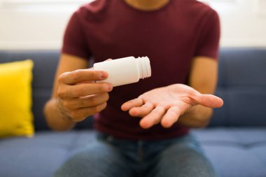 Kafkasyalı genç adam el kremi veya losyon sürüyor ve tasarım için model ürünler kullanıyor.