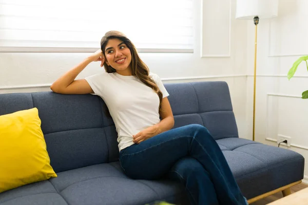 Mujer Joven Feliz Sonriendo Sentada Casa Relajándose Sofá Mientras Usa — Foto de Stock