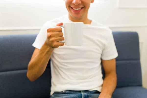 自宅で11ホワイトコーヒーマグをモックアップ製品のデザインのために示す幸せな若者 — ストック写真