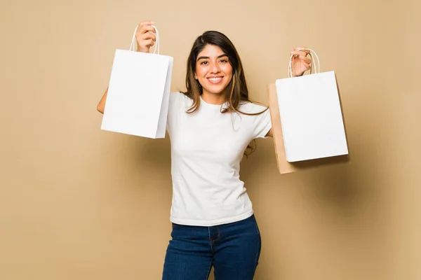 デザインのためのコピースペースを備えた2つの白いモックアップのショッピングバッグを抱いている興奮した若い女性 — ストック写真