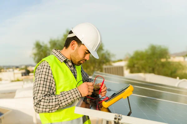 Mladý Muž Pracující Jako Inženýr Kontrolující Solární Panely Používající Multimetr — Stock fotografie