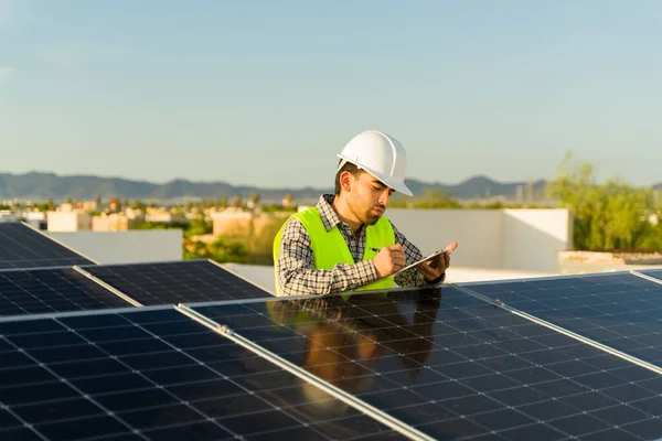 太陽電池を点検している間 住宅の家で太陽電池パネルの取付けに取り組むエンジニアのインストーラ — ストック写真