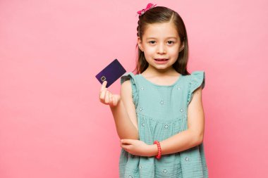 Heyecanlı beyaz çocuk harçlığını ve hediyesini pembe fotokopi alanının yanındaki kredi kartında saklıyor.
