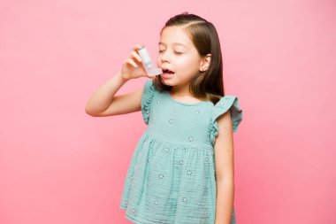 7 yaşında hasta bir çocuk astım krizi geçiriyor. Solunum sorunlarını durdurmak için astım spreyi kullanıyor.