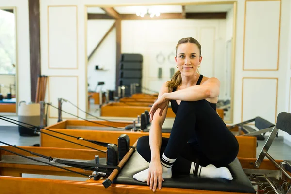 Üst düzey fitness merkezinde pilates dersini bitirirken gülümseyen mutlu beyaz bir kadının portresi.