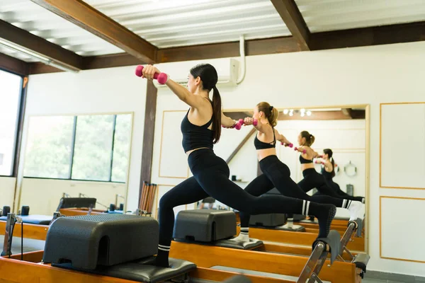 一个积极漂亮的女人在健身馆参加了一个卧床改革者普拉提课 并进行了身体稳定和身体平衡的锻炼 — 图库照片
