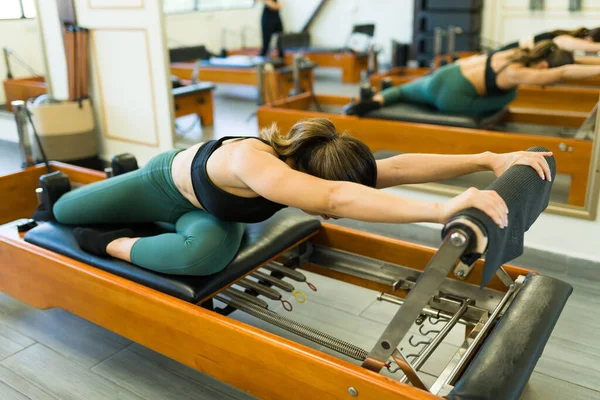 Flexible Young Woman Stretching Her Body Bed Reformer While Exercising — Stock Photo, Image