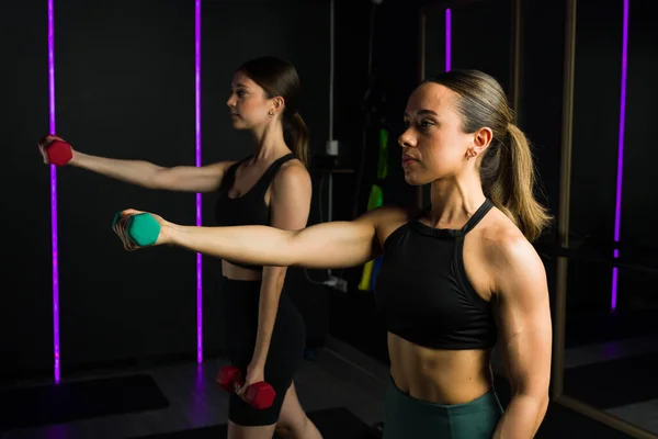 有吸引力的健身妇女在一个功能性培训班上举起哑铃和一起锻炼 — 图库照片