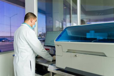 Laboratuvar teknisyeni kan testleri yaparken tıbbi laboratuvarda ekipmanla çalışırken görülmüş.