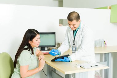 Mutlu kimyager tıbbi test yapmak ve tıbbi laboratuvarda kan almak için hastadan imzasını istiyor.