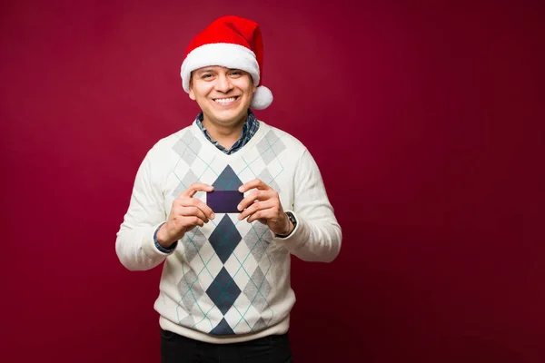 Snygg Latin Man Visar Sitt Kreditkort För Att Köpa Julklappar — Stockfoto