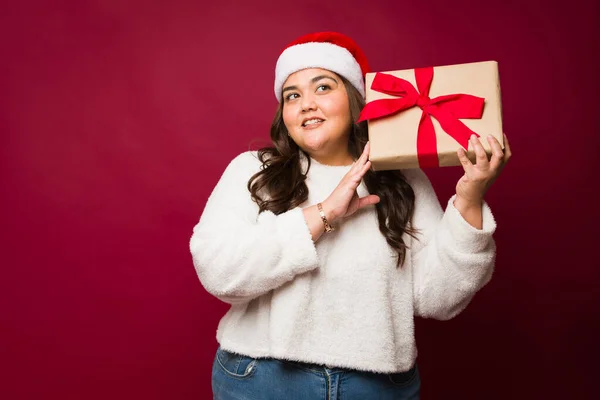 Attractive Obese Young Woman Shaking Her Christmas Gift Wearing Santa — Stock Photo, Image