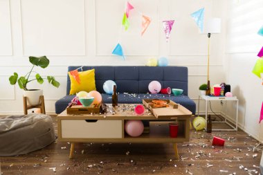 Konfeti, balon ve parti süslemeleriyle dolu bir oturma odası. Bir doğum günü partisini kutladıktan sonra çöplerle ve dağınıklıkla dolu bir felaket. 