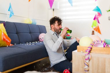 Sabahın erken saatlerinde evde bir doğum günü partisinde tek başına bira içen beyaz bir adam.