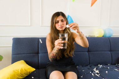 Mide bulantısı çeken ve akşamdan kalma genç hasta bir kadın bir partide çok alkol aldıktan sonra ilaç alıyor.