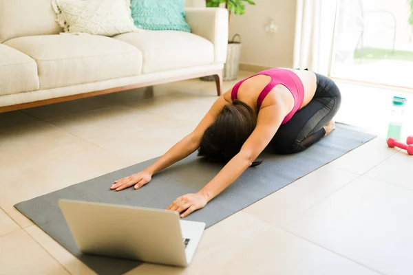 Young woman with a wellness lifestyle stretching after practicing yoga exercises to relax and enjoying her fitness hobby