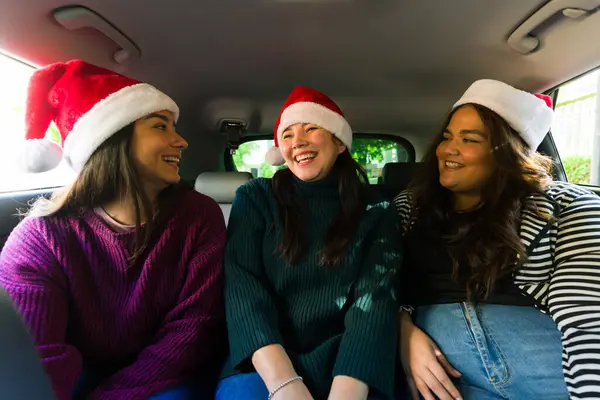 Cheerful women best friends laughing and having fun going shopping together in the car celebrating christmas