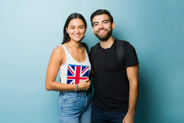 Attractive couple and students hugging and smiling while studying university and learning English together in the UK