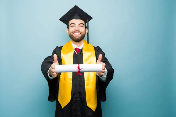 Wesoły Przystojny Mężczyzna Pokazuje Swój Dyplom Uczelni Uśmiecha Się Podczas — Zdjęcie stockowe