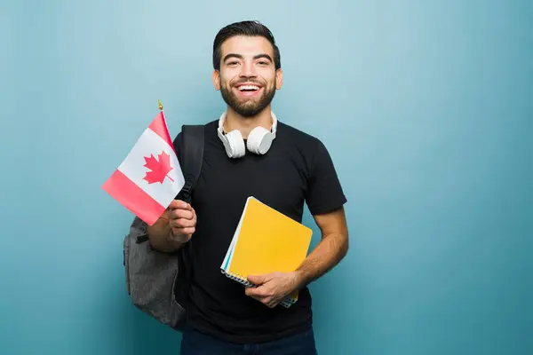 Cheerful hispanic man and student studying English in Canada while carrying books to study abroad in college