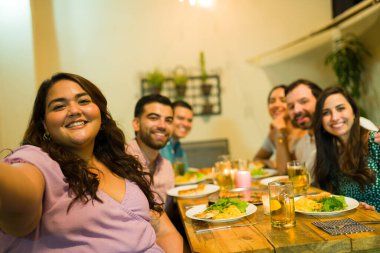 Eğlenceli bir kutlama sırasında masada birlikte yemek yemeye hazır bir grup gencin kişisel perspektifi.