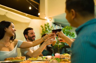 Altı kişilik bir grup, akşam yemeğinde arkadaşlarıyla kadeh kaldırıyor ve şarap içiyor. 