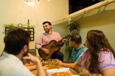 Mutlu çekici bir adam ve arkadaşları gitar çalarken gülüyorlar ve geceleri arka bahçede müzik dinleyip bira içiyorlar.