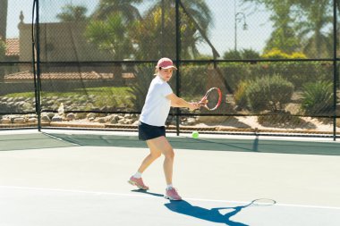 Tenis kortunda spor yapan çekici bir kadın. Açık hava tenis maçında maç yapıyor.