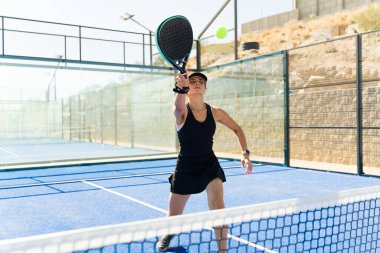 Kafkasyalı aktif kadın bir arkadaşıyla Padek maçı yaparken forehand antrenmanı yapıyor ve egzersiz yapıyor.