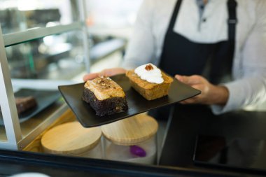 Kahve dükkanında ya da kafede lezzetli bir tatlı siparişi veren bir erkek işçiye yakın durun.