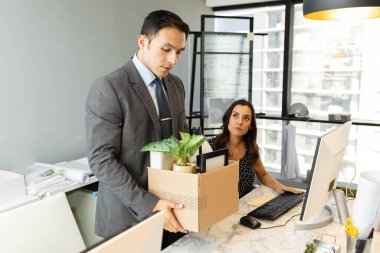 İşadamı kovulduktan sonra üzgün görünüyor ve iş arkadaşları izlerken tüm eşyalarını alıyor.