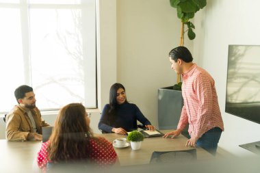 Çeşitli ofis çalışanları toplantı odasında tartışıyorlar.
