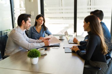 İpotek alan ve toplantı odasında sözleşme imzalayan beyaz bir çiftin profil görüşü.
