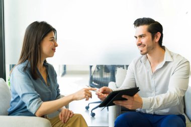 Tabletli Kafkasyalı arkadaş canlısı iş adamı bir kadına kontrat imzalaması için dijital kalem veriyor.