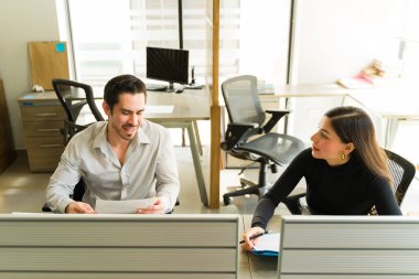 İş adamları, birlikte çalıştıkları bir ofiste çalışırken aynı zamanda çalışmalarını tartışıyorlar.