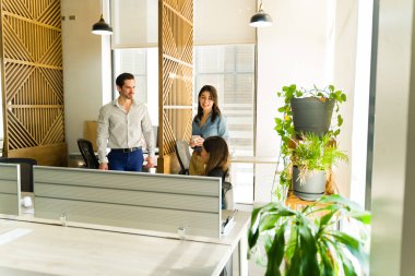 Üç ofis çalışanı ve meslektaşı iş molasında kahve içip dinleniyorlar.