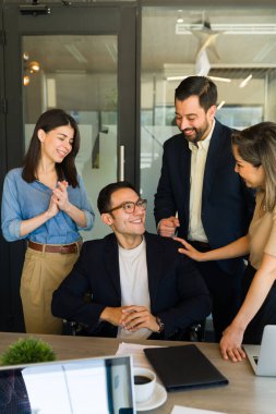 Tekerlekli sandalyede başarılı bir adam. İş arkadaşlarından cesaret ve takdir dolu sözler alıyor.