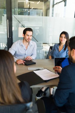 İki iş adamının bir toplantı odasında bazı müşterilerle yaptığı sözleşmeyi gözden geçirmesi.
