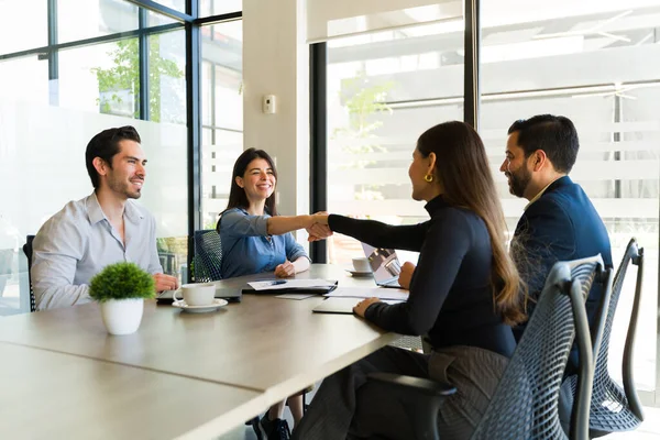 Şirin beyaz çift yeni evleri için ipotek imzaladıktan sonra iş adamlarıyla el sıkışıyor.
