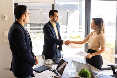 İki iş adamı iş görüşmesi sırasında el sıkışıyorlar.