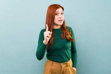 Mavi arkaplan önünde konuşan, hayat tavsiyesi veren ve bahşiş veren çekici kızıl saçlı kadın. 