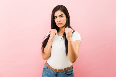 Kızgın Latin kadın üzgün görünüyor ve tartıştıktan sonra yumruklarıyla dövüşmeye hazır. 