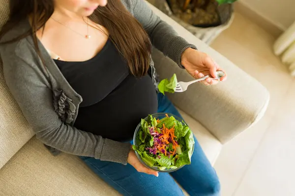 Rahatlamış Sağlıklı Yeşil Salata Yiyen Hamile Bir Kadının Oturma Odasında — Stok fotoğraf