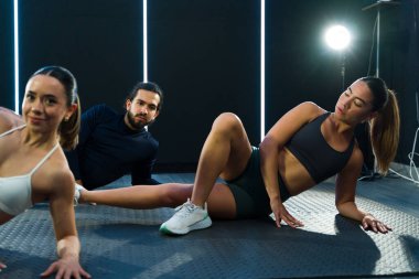 Genç yetişkinlerin çağdaş bir spor salonunda egzersiz yaptığı dinamik fitness sınıfı.