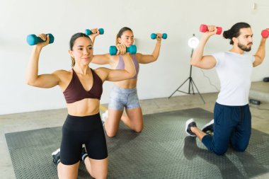 Ağırlık kullanarak spor yapan üç kişi.