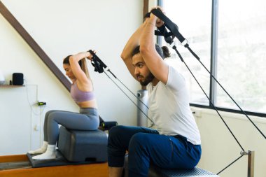 Eğitimli bir eğitmenle fitness stüdyosunda yetişkinler için kapalı pilates antrenmanı.