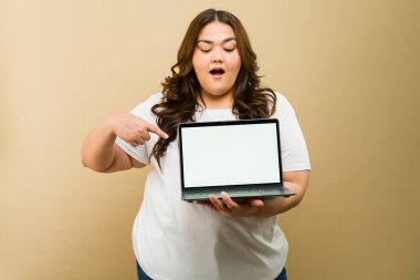 Boş laptop ekranı gösteren mutlu, büyük beden bir kadın. Reklam yerleştirmek için mükemmel.